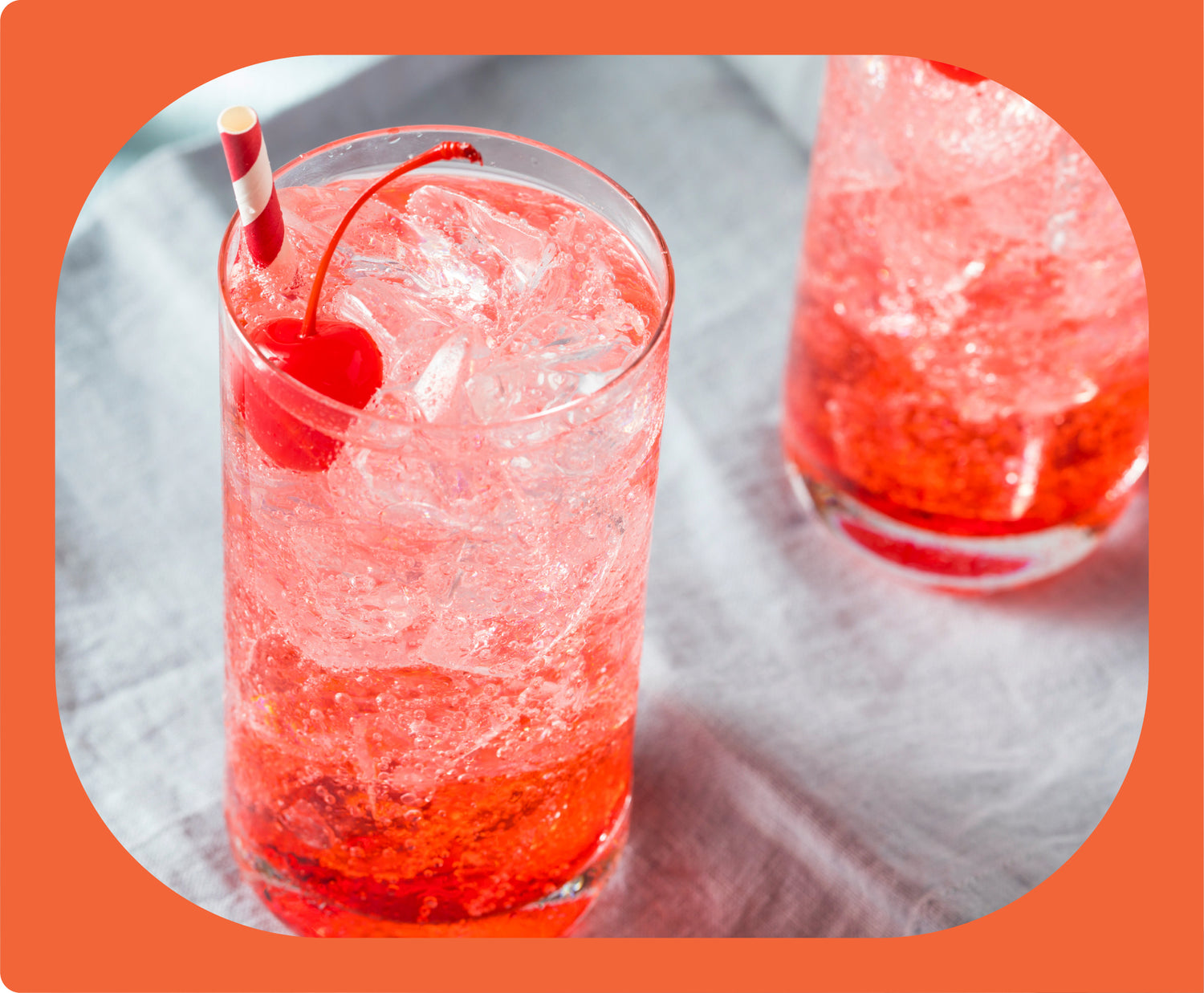 A Shirley Temple with a cherry and red-and-white straw.